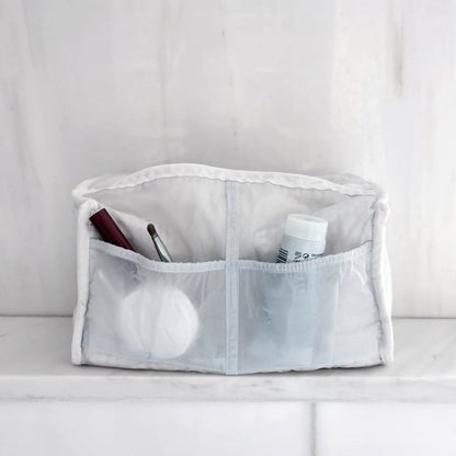 Witte transparante kosmetische organizer met make-up kwast, tube en wattenschijfjes
