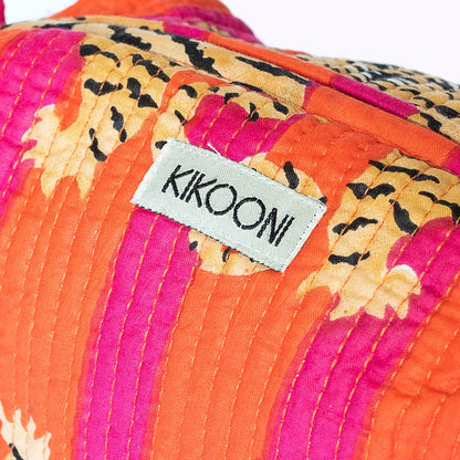 KIKOOON label op kleurrijke geruite stof met oranje, roze en beige tinten