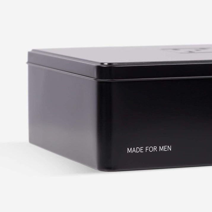 Zwarte metalen doos met de tekst 'MADE FOR MEN' op een witte achtergrond