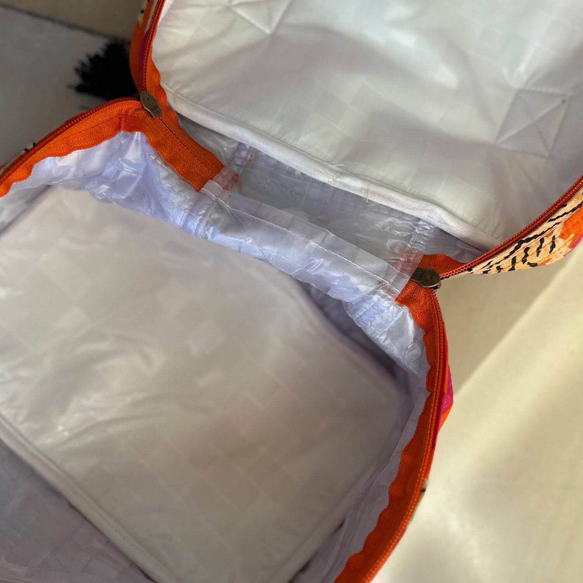 Witte geïsoleerde voering van een koeltas met een oranje ritssluiting