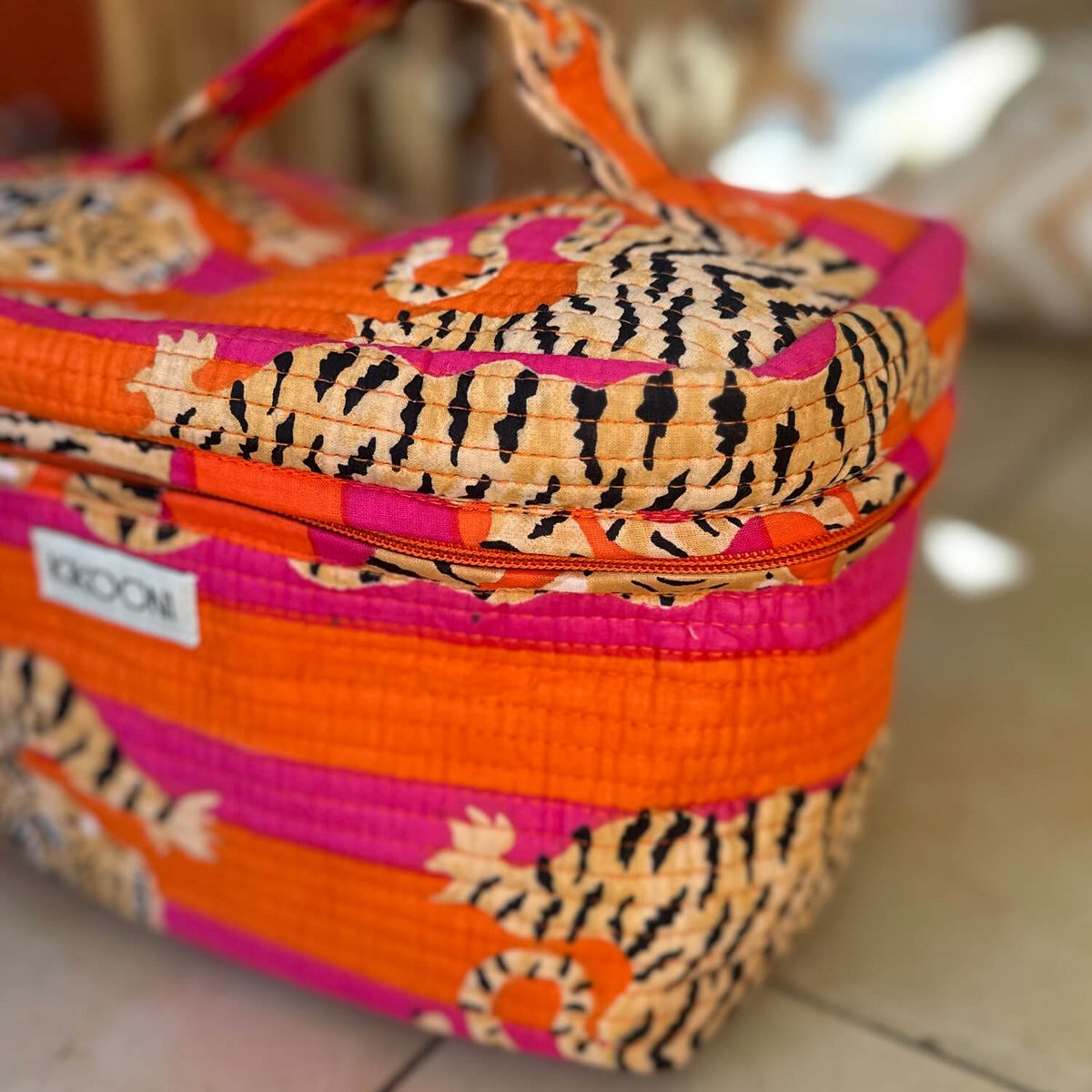 Gekleurde quilted tas met oranje, roze en zwart-wit dierenprint en merklabel KROONI