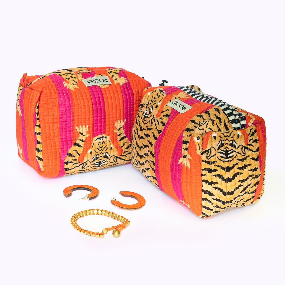 Twee kleurrijke tassen met tijgerprint en oranje strepen, plus oranje oorbellen en armband