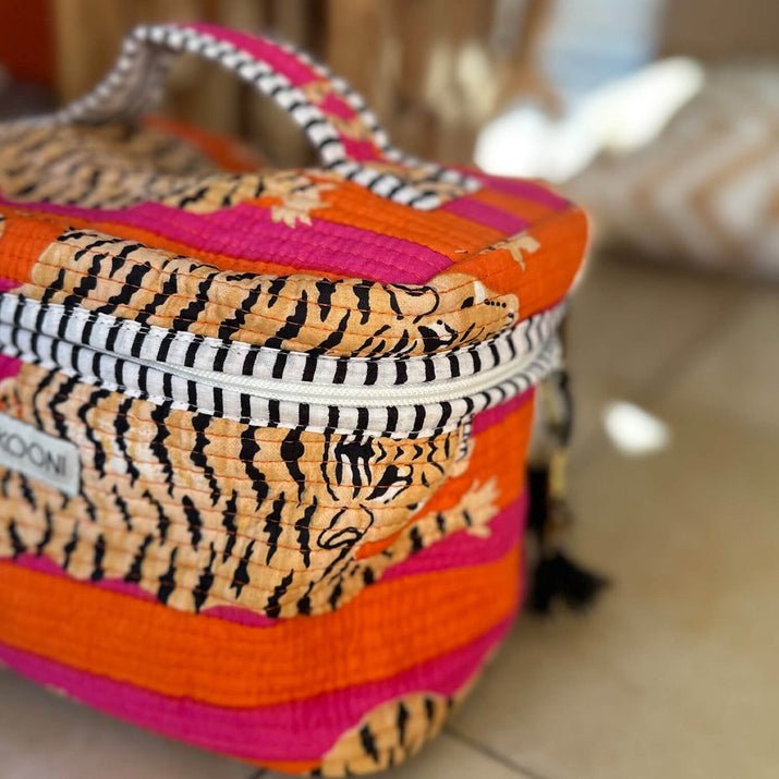 Kleurvolle ritstas met fel oranje, roze en tijgerprint, witte ritssluiting en handvatten