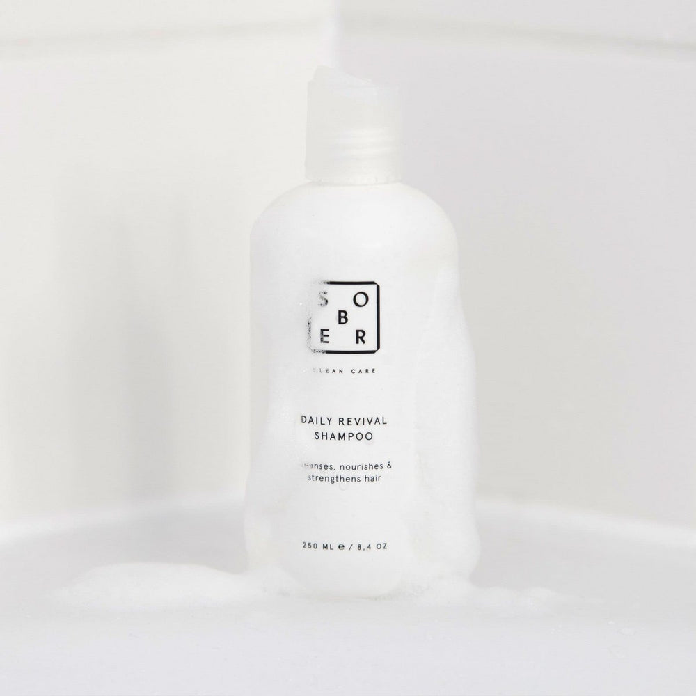 Sober Daily Revival shampoo fles met schuim op witte badkameroppervlakte, haarverzorging product