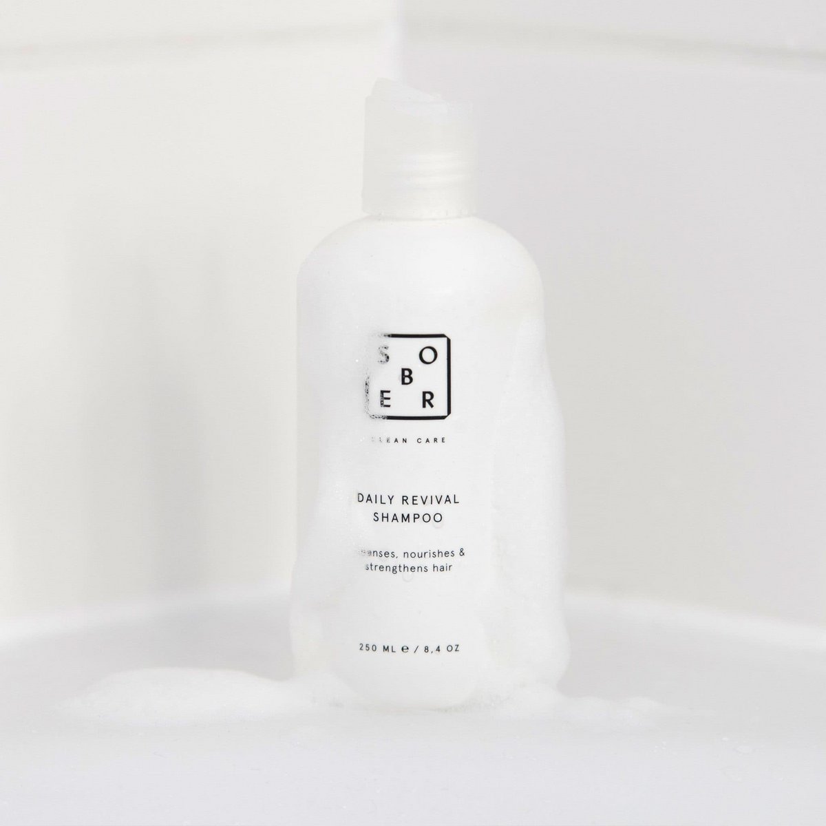 Sober Daily Revival shampoo fles met schuim op witte badkameroppervlakte, haarverzorging product