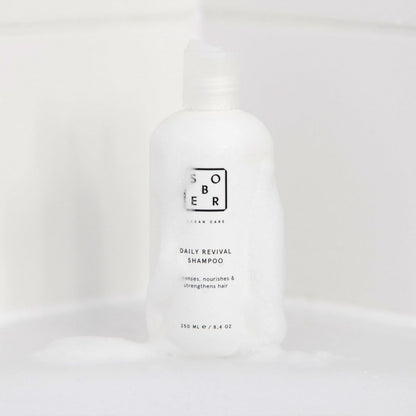 Sober Daily Revival shampoo fles met schuim op witte badkameroppervlakte, haarverzorging product