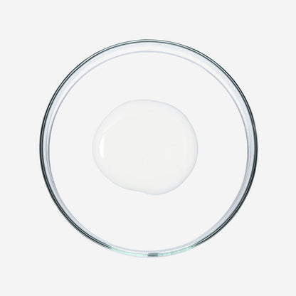 Doorzichtige glazen schaal met een witte vloeistof op witte achtergrond